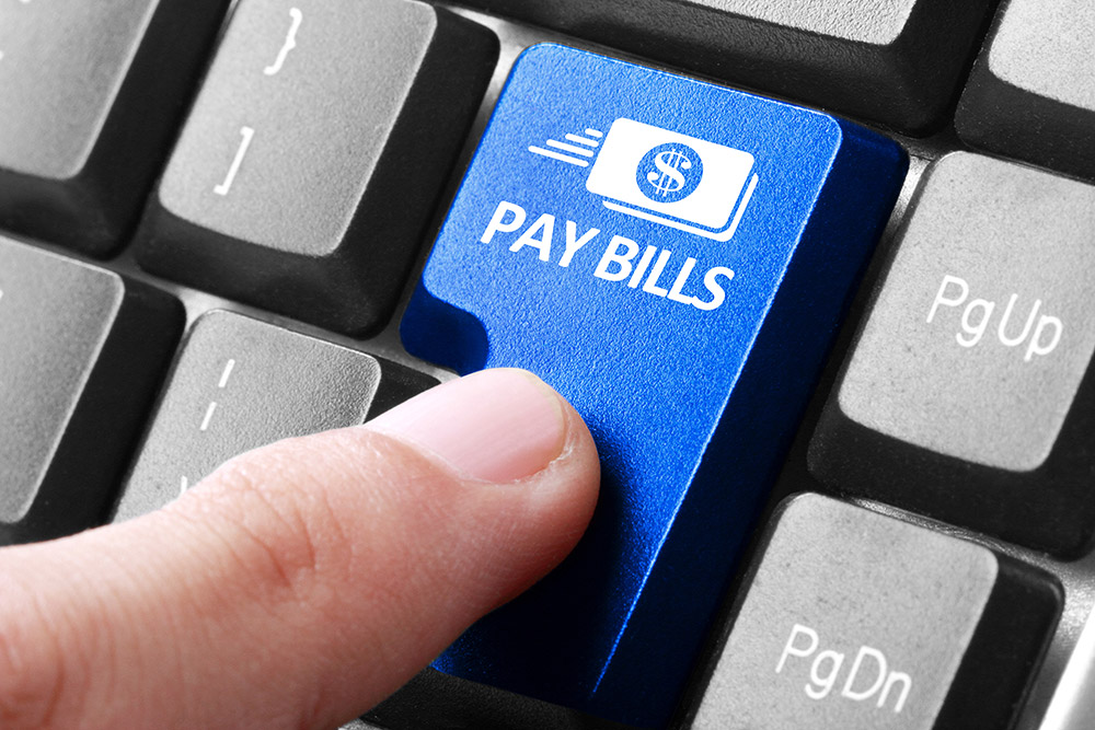 Pay Your Bills Online - Finger hitting PAY BILLS button on keyboard